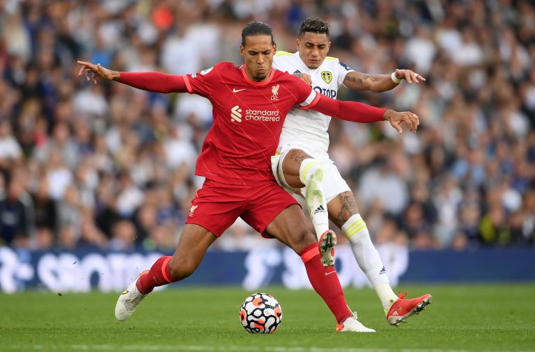 Virgil van Dijk of Liverpool is challenged by Leeds United's Raphinha.