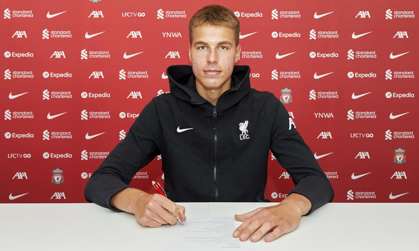 Jakub Ojrzynski signing a Liverpool contract. 
