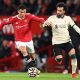 Cristiano Ronaldo of Manchester United holds off Mohamed Salah of Liverpool.