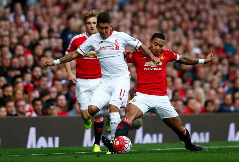 Memphis Depay of Manchester United contests for the ball with Liverpool's Roberto Firmino.