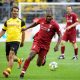 Liverpool's Salif Diao plays against Karl-Heinz Riedle during the friendly legends game in August 2018.