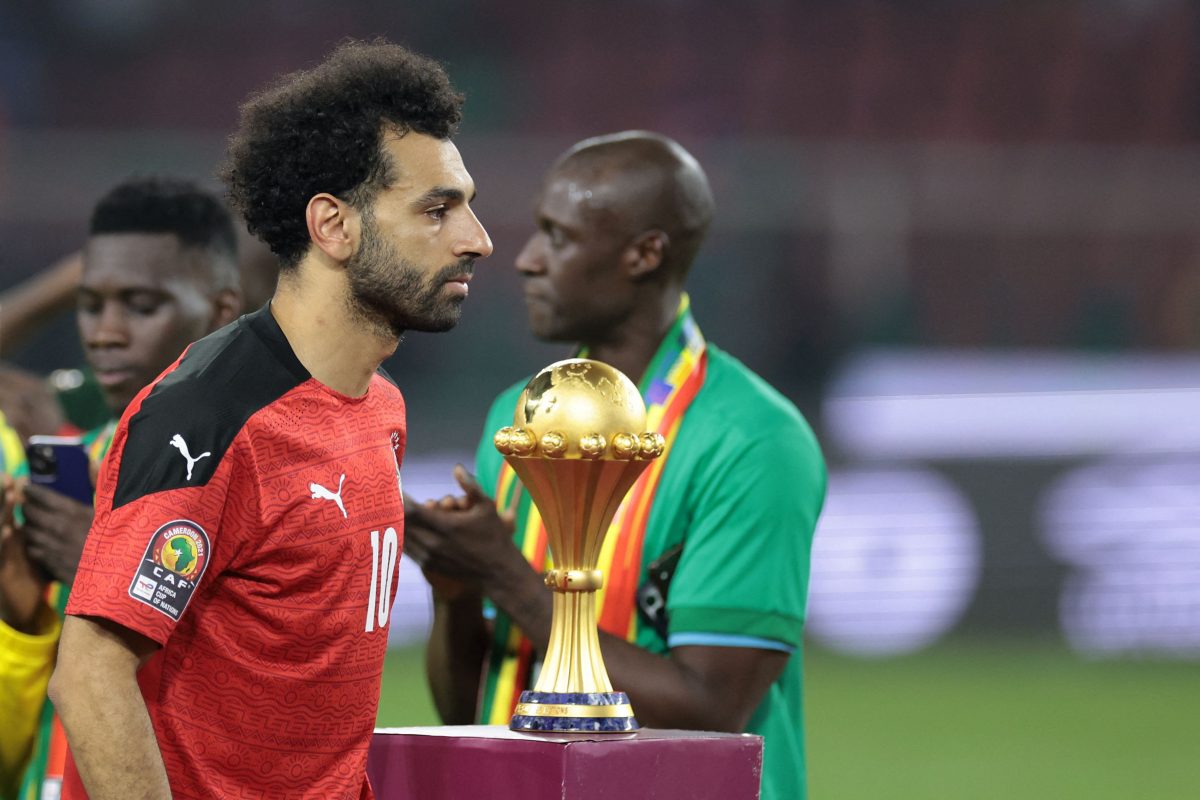 Egypt's Mohamed Salah walks past the AFCON Trophy after losing to Senegal.