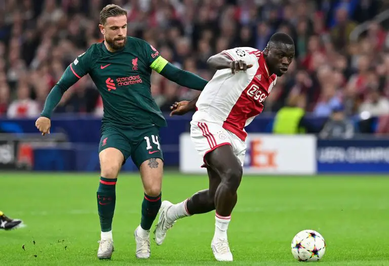 Liverpool's Jordan Henderson fights for the ball with Ajax's Brian Brobbey.