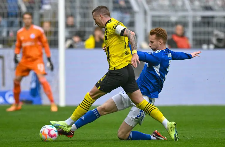 Borussia Dortmund's Marco Reus vies for the ball with Liverpool loanee and Schalke defender, Sepp van den Berg.