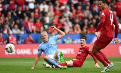 Andy Robertson looks on as Erling Haaland of Manchester City has a shot on goal whilst under pressure from Virgil van Dijk of Liverpool during The FA Community Shield final.