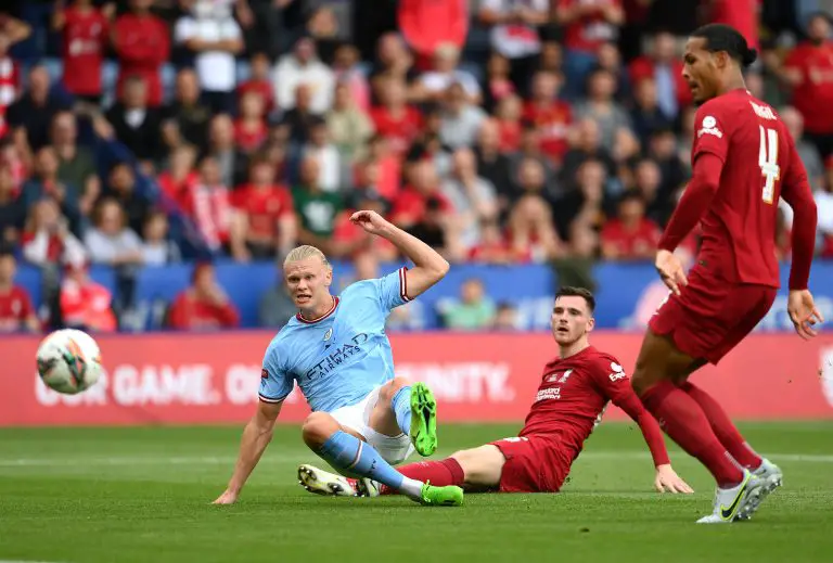 Andy Robertson looks on as Erling Haaland of Manchester City has a shot on goal whilst under pressure from Virgil van Dijk of Liverpool during The FA Community Shield final.