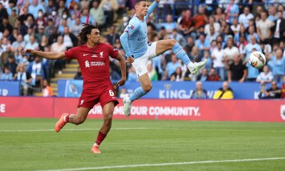Phil Foden of Manchester City kicks the ball under pressure from Trent Alexander-Arnold of Liverpool. (