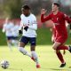 Romaine Mundle of Tottenham Hotspur U21 runs away from Calvin Ramsey of Liverpool U21.