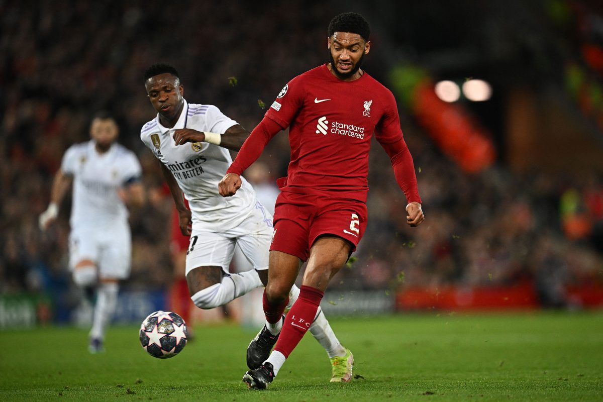 Real Madrid's Vinicius Junior watches as Liverpool's Joe Gomez pass the ball back to goalkeeper Alisson Becker.