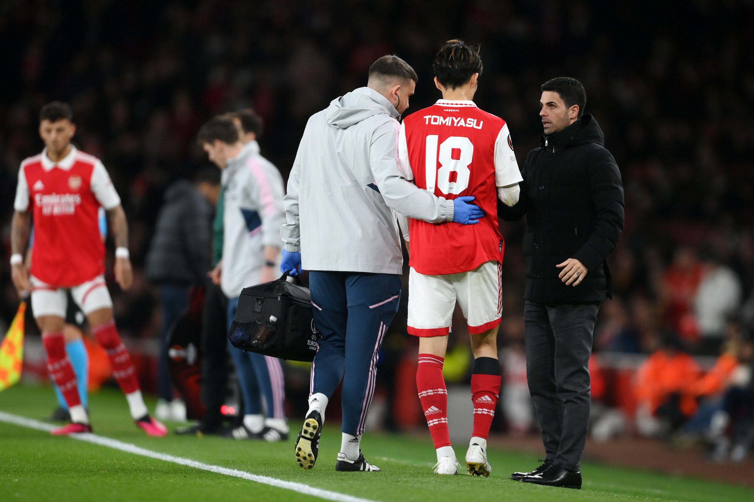 Mikel Arteta of Arsenal speaks to Takehiro Tomiyasu as he leaves the pitch after picking up an injury.