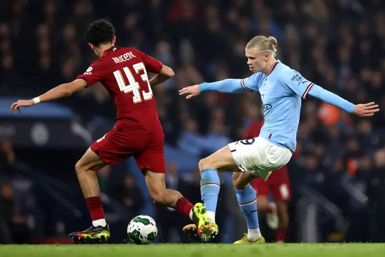 Erling Haaland of Manchester City holds off pressure from Stefan Bajcetic of Liverpool.