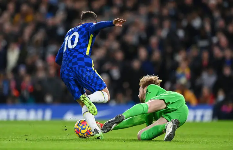 Caoimhin Kelleher of Liverpool makes a save against Christian Pulisic of Chelsea.