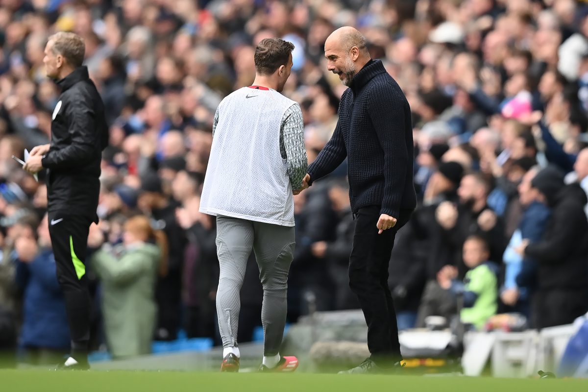 Pep Guardiola shakes Liverpool substitute Arthur Melo's hand after Manchester City score against Liverpool.