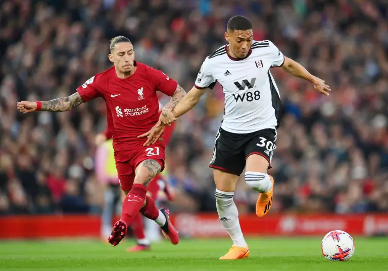 Carlos Vinicius of Fulham runs with the ball whilst challenged by Kostas Tsimikas of Liverpool.