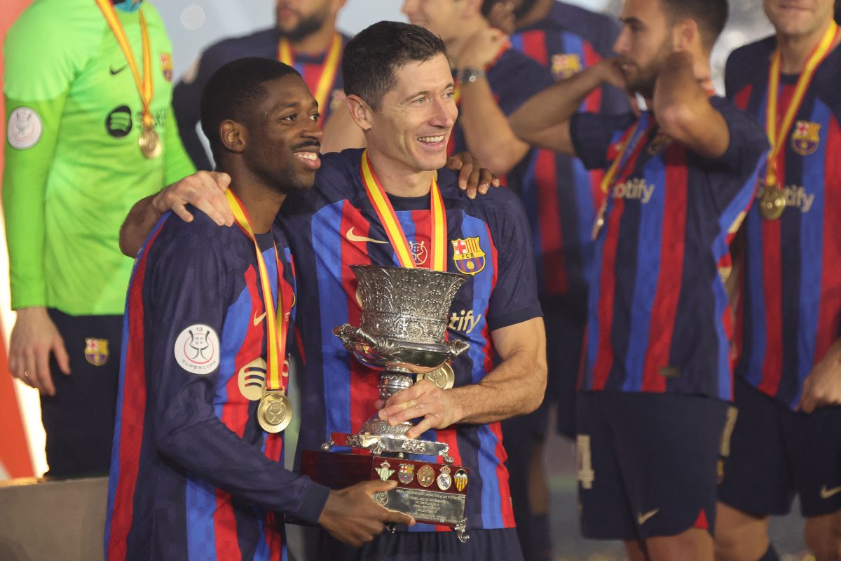 Barcelona's French forward Ousmane Dembele and Robert Lewandowski with the Spanish Super Cup. 