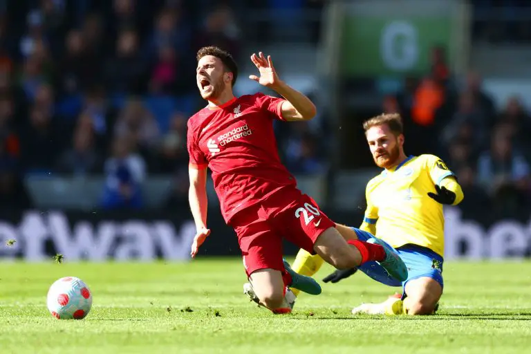 Diogo Jota of Liverpool is tackled by Alexis Mac Allister of Brighton.