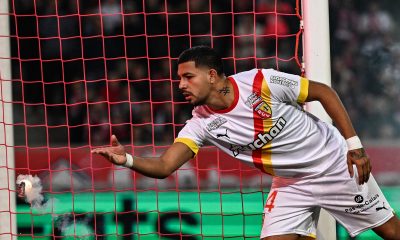 Lens' Austrian defender Kevin Danso throws back a flare thrown by Lille's supporters in an intense Ligue 1 game.