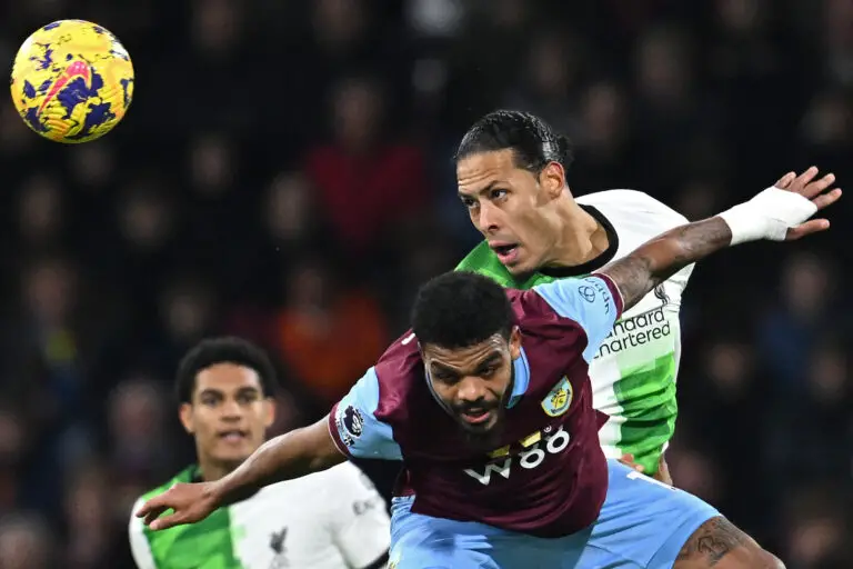 Liverpool's Dutch defender #04 Virgil van Dijk (R) vies with Burnley's South African striker #17 Lyle Foster (C) during the English Premier League football match between Burnley and Liverpool at Turf Moor in Burnley, north-west England on December 26, 2023. (Photo by Paul ELLIS / AFP) / RESTRICTED TO EDITORIAL USE. No use with unauthorized audio, video, data, fixture lists, club/league logos or 'live' services. Online in-match use limited to 120 images. An additional 40 images may be used in extra time. No video emulation. Social media in-match use limited to 120 images. An additional 40 images may be used in extra time. No use in betting publications, games or single club/league/player publications. / (Photo by PAUL ELLIS/AFP via Getty Images)