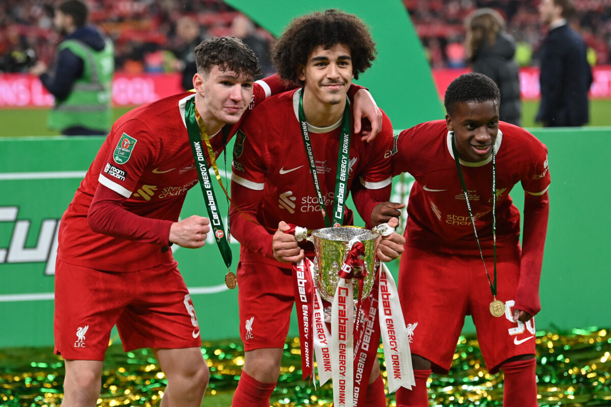 Liverpool's English striker #67 Lewis Koumas (L), Liverpool's English striker #76 Jayden Danns (C) and Liverpool's English midfielder #98 Treymaurice Nyoni  pose with the trophy following the English League Cup final football match between Chelsea and Liverpool at Wembley stadium, in London, on February 25, 2024. Virgil van Dijk scored the only goal deep into extra-time as Liverpool won the League Cup for a record tenth time. (Photo by Glyn KIRK / AFP) / RESTRICTED TO EDITORIAL USE. No use with unauthorized audio, video, data, fixture lists, club/league logos or 'live' services. Online in-match use limited to 120 images. An additional 40 images may be used in extra time. No video emulation. Social media in-match use limited to 120 images. An additional 40 images may be used in extra time. No use in betting publications, games or single club/league/player publications. /  (Photo by GLYN KIRK/AFP via Getty Images)