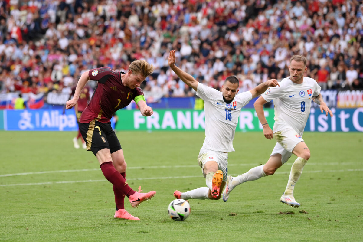 FRANKFURT AM MAIN, GERMANY - JUNE 17: Kevin De Bruyne of Belgium shoots whilst under pressure from David Hancko of Slovakia during the UEFA EURO 2024 group stage match between Belgium and Slovakia at Frankfurt Arena on June 17, 2024 in Frankfurt am Main, Germany. (Photo by Stu Forster/Getty Images)